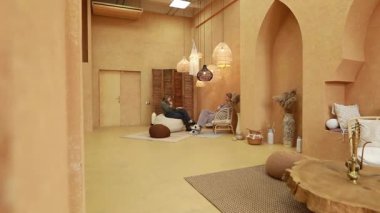 Arkadaşlar minimalist, sıcak tonlu bir yerde eşsiz dekorlar ve yumuşak mobilyalarla sakin bir anın tadını çıkarıyorlar. Ortam sakin ve davetkar. Sohbet için mükemmel..