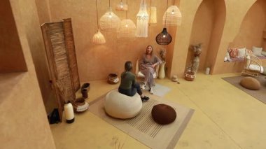 İki insan kapalı bir alanda anlamlı bir sohbete girişiyor. İçinde dünya renkleri ve eşsiz aydınlatma armatürleri var. Ortam sıcak, davetkar ve teşvik edici..