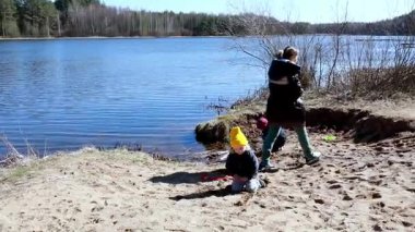 Bir aile göl kenarında güzel bir bahar gününün tadını çıkarıyor, çocuklar kumu kazıyor ve kıyı şeridini keşfediyor. Kendi maceralarını yaratırken kahkahalar havayı doldurur..