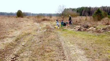 Baharın başlarında bir tarlada fırçayı temizlemek için iki kişi işbirliği yapar. Biri el arabası kullanırken diğeri enkazı düzenliyor ve doğada takım çalışması sergiliyor..