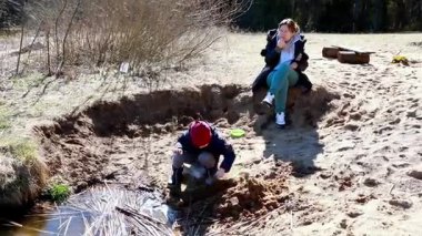 Biri kumu kazarken, diğeri ağaçlarla çevrili ve dingin bir gölet olan diğerini gözlemlerken, iki çocuk yaratıcı bir oyun oynuyor. Açık hava maceraları hayal gücünü ve takım çalışmasını gözler önüne seriyor..
