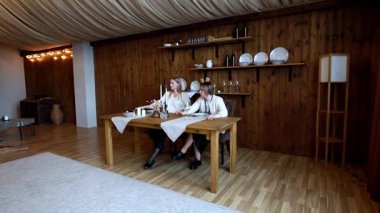 Büyüleyici, kırsal bir ortamda, iki kadın bir toplantı için sahne hazırlıyor. Dekor ve sofra takımlarını dikkatlice düzenleyip misafirler için davetkar bir ortam yaratıyorlar..