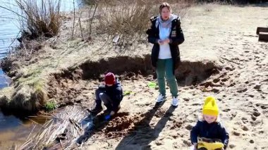 İki çocuk gölün kenarında bir günün tadını çıkarıyorlar, kumsalda oynuyorlar ve oyuncak kamyonlarla deney yapıyorlar. Bir çocuk inşa etmeye odaklanırken diğeri suları keşfediyor..