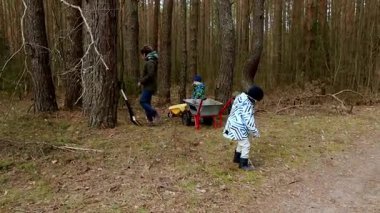 Ormanda doğayla iç içe olan bir aile. Yetişkinler ve çocuklar bahçeyle ilgilenmek için birlikte çalışırken dışarıda kaliteli zaman geçiriyorlar. Herkes neşeli ve hareketli görünüyor..