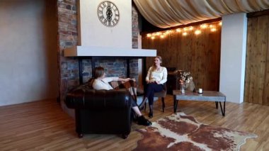 İki kadın sıcak, davetkar bir yerde ahşap aksanlı ve şömineli konuşuyorlar. Atmosfer rahat ve verimli tartışmalar veya kişisel sohbetler için mükemmel..