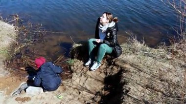 Bir çocuk yakınlarda oynarken bir kadın nehir kenarında oturuyor. Açık bir günde doğa ile çevrilidirler, birlikte dışarıda geçirdikleri zamanın tadını çıkarırlar. Atmosfer huzurlu ve rahat..