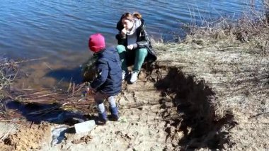Bir kadın ve bir çocuk göl kenarında güzel bir gün geçirir, atıştırmalıkların tadını çıkarırlar, kumda oynarlar, ve bahar güneşinin erken saatlerinde doğal çevreyi keşfederler..