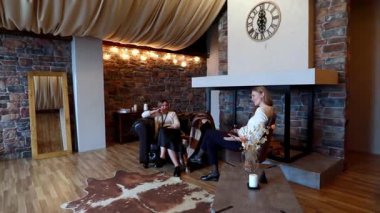 İki arkadaş, taştan duvarları ve sıcak ışıklandırması olan büyüleyici kırsal bir oturma odasında rahat bir sohbetin tadını çıkarıyor. Atmosfer davetkar ve huzurlu. Bağlanmak için mükemmel..