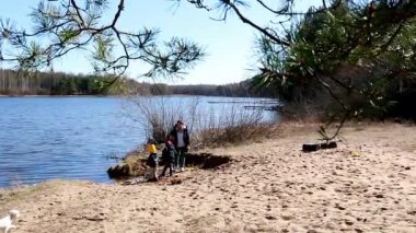 Çocuklar göl kenarında güneşli bir günün tadını çıkarırlar, kumlu sahil boyunca oynarlar ve çevreyi keşfederler. Huzurlu ortam onların eğlenceli aktivitelerini geliştirir..