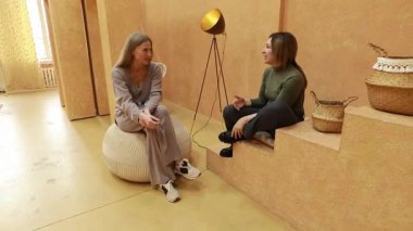 İki kadın yaratıcı bir şekilde tasarlanmış stüdyo alanında canlı bir sohbete girişiyor. Sıcak atmosfer tarafsız tonlara ve benzersiz dekorlara sahip, işbirliğini teşvik eden ve ilham veren.