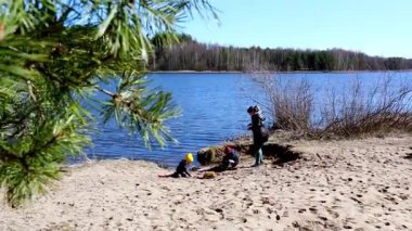 Üç çocuk, açık hava aktiviteleriyle meşgul olarak nehir kıyısında sıcak bir bahar gününün tadını çıkarıyorlar. Doğal materyalleri toplarlar, yaratıcılığı ve keşifleri huzur ortamında teşvik ederler..