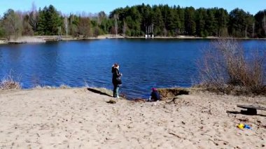 Bir aile gölde aydınlık bir gün geçirir. Bir ebeveyn, bir çocuğun kumsalda oynadığı günleri yönetir. Temiz su ve yeşil ağaçlar dışarıda huzurlu bir eğlence ortamı yaratıyor..