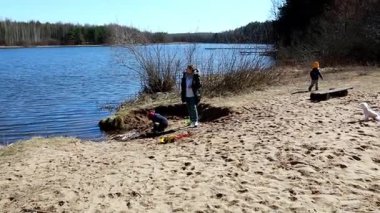 Çocuklar dingin bir gölün kenarındaki neşeli anların tadını çıkarırlar. Çubukları toplarlar ve kumlu kıyıları keşfederler. Doğayla iç içe olan parlak bir öğleden sonra..