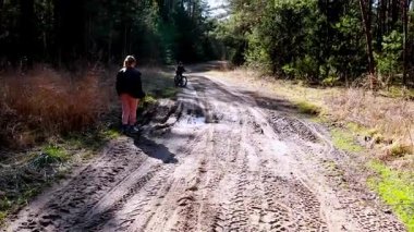 İki arkadaş, güneşli bir ilkbahar öğleden sonrasında, ağaçlarla ve doğal manzaralarla çevrili, ağaçlık bir alanda tozlu bir yolda birlikte dolaşır ve dışarıda vakit geçirir..