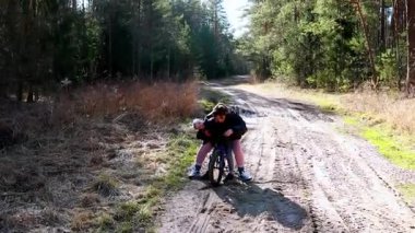 Bir çocuk sessiz bir orman patikasını keşfederken bisiklete binmekten zevk alır. Güneş ağaçların arasından parlıyor, dışarıda oynamak ve keşfetmek için huzurlu bir atmosfer yaratıyor..