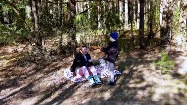 Bir anne ve küçük oğlu huzurlu bir orman ortamında birlikte güzel vakit geçiriyorlar. Anne battaniyeye sarılıp günün sıcaklığının tadını çıkarırken çocuk doğayla şakalaşıyor..