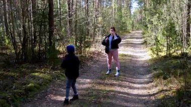 Bir kadın ve oğlu, uzun ağaçlar ve yeşilliklerle çevrili sakin bir orman yolunda yürüyor. Güzel bir günde doğanın güzelliğinin tadını çıkarıyorlar, beraberlik anları yakalıyorlar..