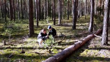 İki birey, bitkileri ve vahşi yaşamı gözlemlemeye ve incelemeye odaklanmış yemyeşil bir ormanı araştırıyor. Güneş ışığı ağaçların arasından süzülerek sakin bir atmosfer yaratır..