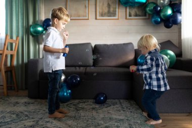 İki çocuk balonlarla dolu sıcak bir odada neşeyle kabarcıklarla oynuyorlar. Bir çocuk baloncuk üflerken diğeri dans ediyor, birlikte neşeli bir anın tadını çıkarıyor..