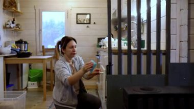 Bir kadın mutfağını sıcak ve davetkar bir yere yerleştirirken görülüyor. Evinin rahatlığıyla eğlenirken eşyaları dikkatlice düzenler. Atmosfer huzurlu ve misafirperver..