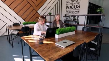 Çağdaş bir ofis alanında iki profesyonel birlikte çalışırlar. Çevrede büyük ahşap tablolar, yeşillik ve verimli bir atmosferi destekleyen motivasyon alıntıları yer alıyor..