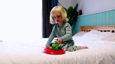 Genç bir çocuk yaratıcı bir oyun oynamakla meşgul, renkli yapı taşlarını bir yatakta birleştiriyor. Işık dolu oda hayal gücünü ve keşifleri teşvik eder..