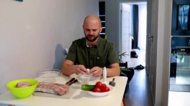 Bir insan sıcak bir mutfak ortamında malzemeleri hazırlamakla meşgul. Taze sebzeler ve et, o görevine odaklanırken, lezzetli bir yemek yapmaya hazırlanıyor..