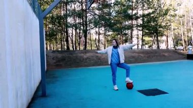 Genç bir kadın futbol yeteneklerini açık hava ortamında mavi bir kortta çalışıyor..