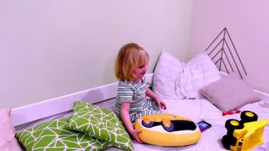 Genç bir çocuk, yumuşak yastıklar ve neşeli oyuncaklarla dolu rahat bir köşede eğlenceli aktivitelere girişir. Mekan parlak ve davetkar. Keşif ve eğlence için ideal..