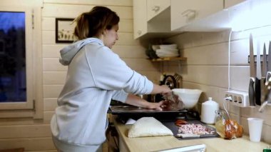 Taze sebze ve etle dolu mutfak tezgahında malzemeleri ustalıkla hazırlayan bir insan. Sıcak gün batımı ışığı sahneye samimi bir ortam ekler..