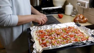 Eller taze kesilmiş sebze ve eti bir ev mutfağındaki hamura ekler. Sıcak, davetkar atmosfer, aşçılığa ve canlı malzemelere olan sevgisini gösteriyor..