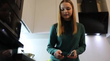 Bir insan şık bir mutfakta yemek hazırlar, sebzeleri ustalıkla doğrar ve malzemeleri düzenler. Yumuşak ışıklandırma sıcak bir atmosfer yaratarak yemek pişirme deneyimine katkı sağlar..