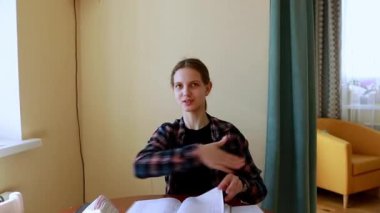 Konforlu bir ev ortamında, bir öğrenci notları gözden geçirirken ve tartışmalara girerken özenle ders çalışır. Sıcak atmosfer öğrenmeye odaklanır..