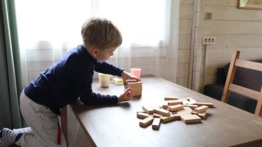 Genç bir çocuk evde annesiyle klasik masa oyunu Jenga oynuyor. Birlikte çok eğleniyorlar. Kuleden blokları dikkatlice kaldırıyorlar ve yıkılmaması için uğraşıyorlar..