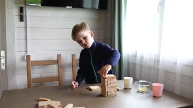 Genç bir çocuk annesiyle klasik Jenga oyunu oynuyor. Dikkatlice kuleden bir blok kaldırıyor, çökmemesi için çabalıyor. Aile birlikte vakit geçirmekten, oyun oynamaktan hoşlanıyor.