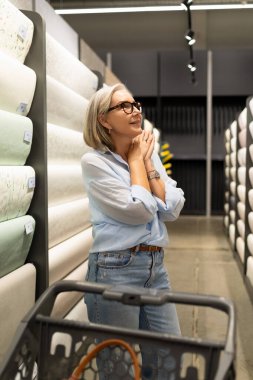 Bir kadın, alışveriş deneyimini bir süpermarkette, mutfak eşyaları, bahçe malzemeleri ve aletler gibi çeşitli bölümlere göz atarak geçirir..