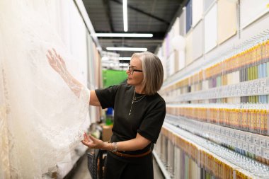 Farklı kumaşlar ve dokularla ilgilenen bir kadın, ev eşyaları satan bir mağazada kurbanlarını keşfeder. Odaklanması, alışveriş yaparken yaşam alanı için yeni bir dekor keşfetme zevkini gözler önüne seriyor..