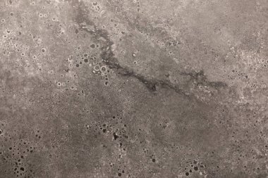 Yakından bakınca, eşsiz desenleri ve küçük delikleri olan desenli gri bir yüzey ortaya çıkıyor. Bu malzeme çeşitli yapı ve tasarım uygulamalarında çok yönlülüğünü göstererek kullanılabilir..