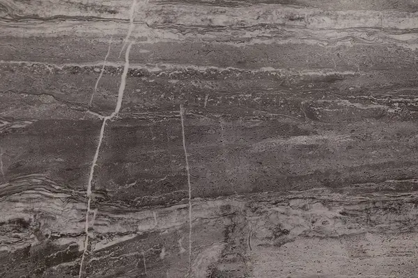 Bu gri mermer yüzey, doğal güzelliğini vurgulayan karmaşık damar ve dokulara sahiptir. İç tasarım için ideal, çeşitli alanlara zarafet ekler.