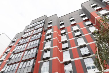 Çerçeve, hareketli bir yerleşim bölgesinde modern mimari tarafından karakterize edilen yüksek katlı apartman binalarını yakalıyor, kira ve ipotek seçeneklerini vurguluyor.