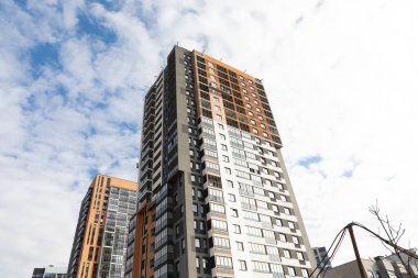 Büyüyen bir yerleşim yerinin kira ve mülkiyet seçeneklerini vurgulayan hareketli şehir ortamında, yüksek apartman daireleri ufuk çizgisine hakim durumda..