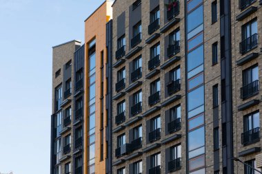 Manzara, her biri canlı bir yerleşim alanındaki kentsel yaşam ve barınma olanaklarını ön plana çıkaran eşsiz tasarımlar içeren çağdaş yüksek binalar dizisini yakalıyor..