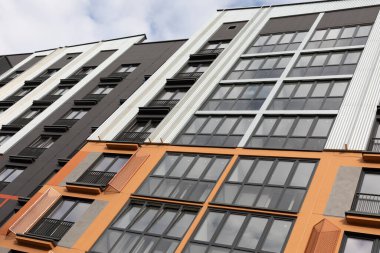 Görüntü, lüks mimari ve çeşitli kiralama seçeneklerini vurgulayarak, bir yerleşim yerindeki modern yüksek katlı apartman binalarını yakalıyor..