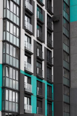 Çağdaş bir konut binasında parlak çizgiler ve renkli aksanlar, hareketli bir mahallede kiralık daireler ve ipotek seçenekleri için kullanılabilir daireler vurgulanıyor.