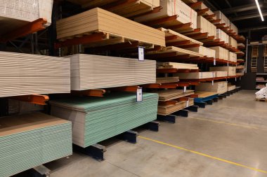 Bir tamirhanenin içinde, çeşitli kontrplak ve çarşaflar düzenli olarak raflara dizilir. Müşteriler kalabalık bir öğleden sonra erzak aramak için koridorları tarar..