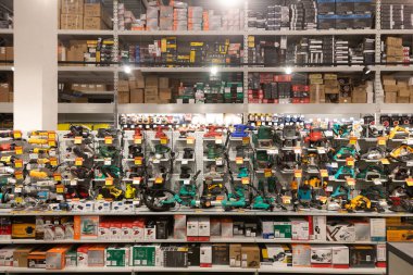 Parlak ışıklandırılmış hırdavat mağazası düzenli olarak düzenlenmiş geniş bir alet ve ekipman dizisine sahip. Müşteriler ev onarımı ve iyileştirme için kolaylıkla eşya bulabilirler..