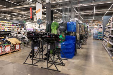 Müşteriler, tamir aletleri, depolama malzemeleri ve açık hava teçhizatlarıyla dolu geniş bir hırdavatçıyı keşfediyorlar. Işıl ışıl koridorlar ev geliştirme için geniş bir malzeme seçimi sunuyor.