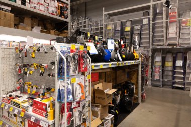 Müşteriler yerel bir hırdavatçıda geniş bir araç ve onarım malzemesi yelpazesini keşfedebilirler. Koridorlar düzenlidir, çeşitli el aletleri ve ekipmanları sergilenir..