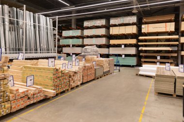 İnşaat malzemeleri ve donanımlarla dolu raflar geniş bir tamir dükkanında görülebilir. Çeşitli odun ve malzemeler müşteriler tarafından kolay erişim için düzenli olarak istiflenir..