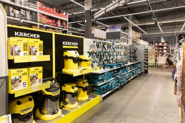 Bir hırdavatçıdaki raflarda çeşitli temizlik makineleri ve elektrikli aletler düzenli olarak düzenlenir. Parlak ışıklandırma, müşterilere ürünleri net görme ve alışveriş deneyimlerini geliştirme olanağı sağlıyor..